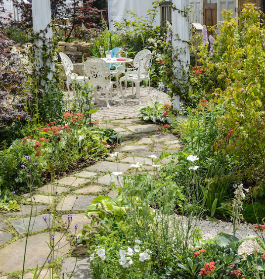 Crazy-paved garden path leading to table setting at BBC Gardeners' World Live