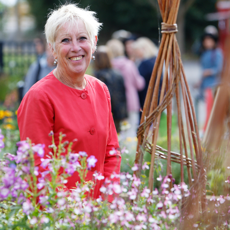 Celebrity gardener Carol Klein smiling among flowers at BBC Gardeners' World Live