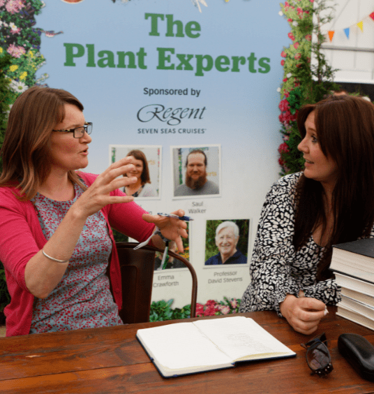 Two plant experts sitting and chatting with books at BBC Gardeners' World Live