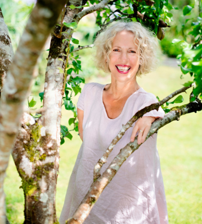 Celebrity gardener Sue Kent smiling among tree branches